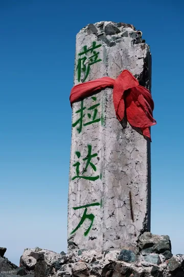 A monument against a snowy mountain sky